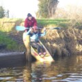 Girl entering the water in a Canoe